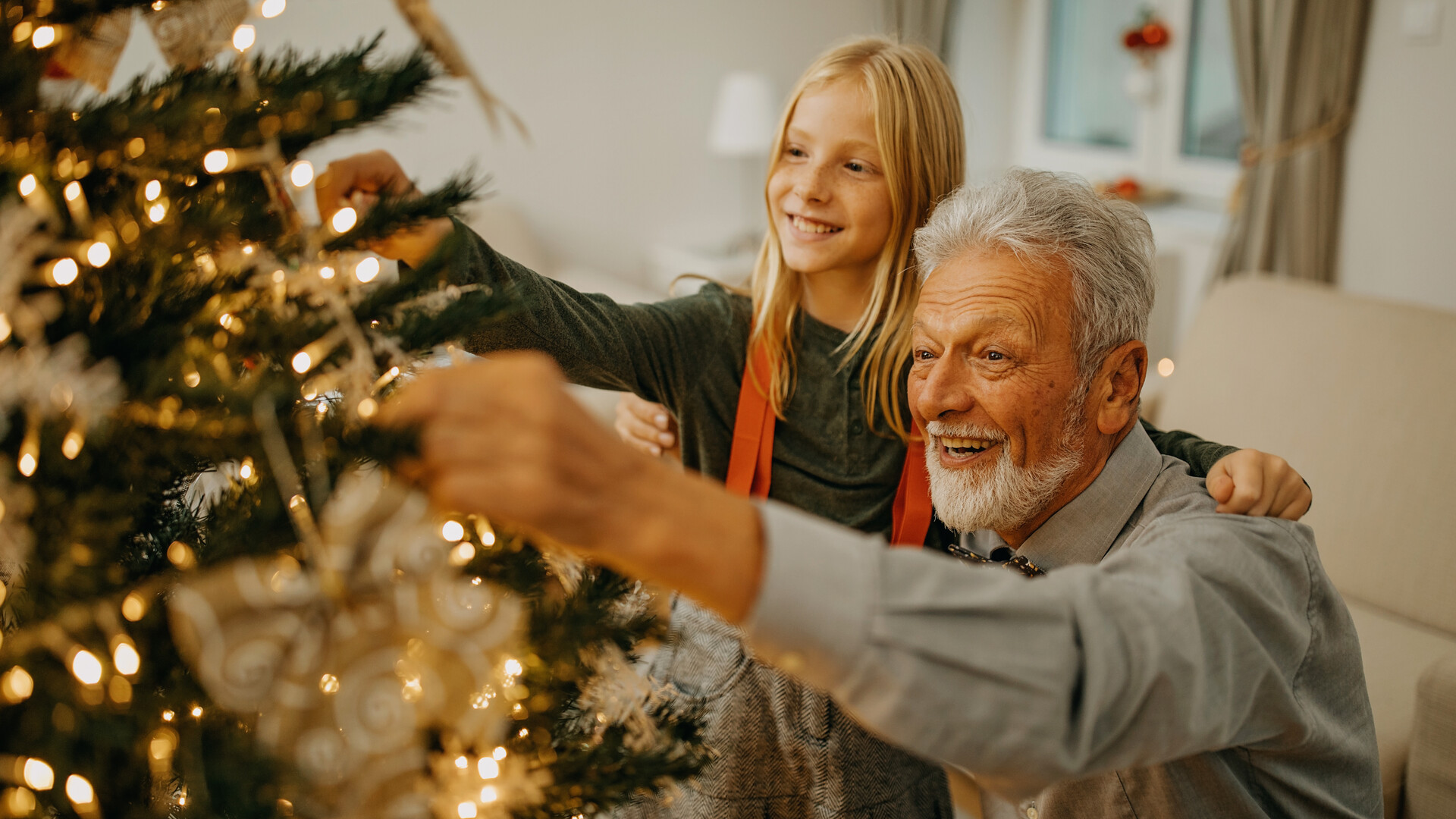 Senior Mann und Enkelin schmücken Weihnachtsbaum Senior Mann und Enkelin schmücken Weihnachtsbaum